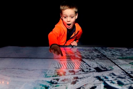 A child uses interactive displays at the Two Cities exhibition